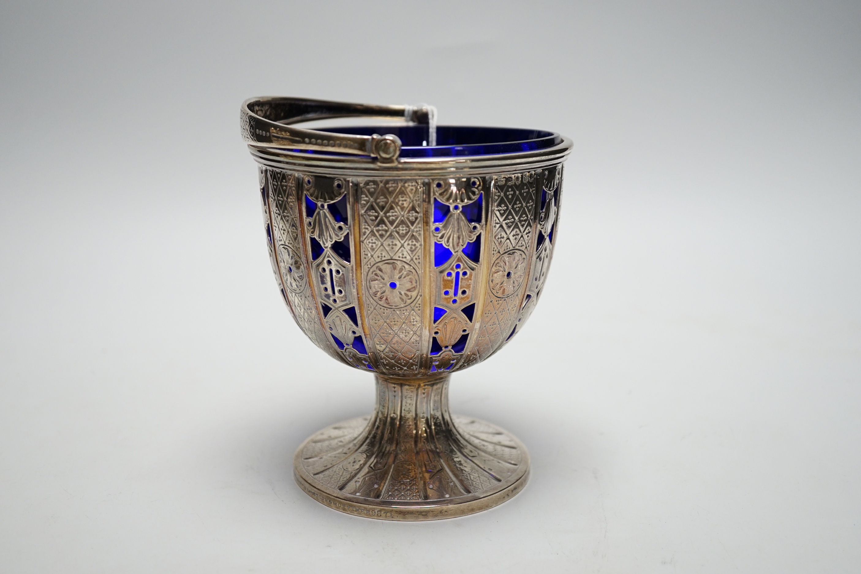 A Victorian pierced silver pedestal sugar basket, by John Samuel Hunt, London, 1859, with blue glass liner, height 13.1cm excluding handle, 12.4oz.